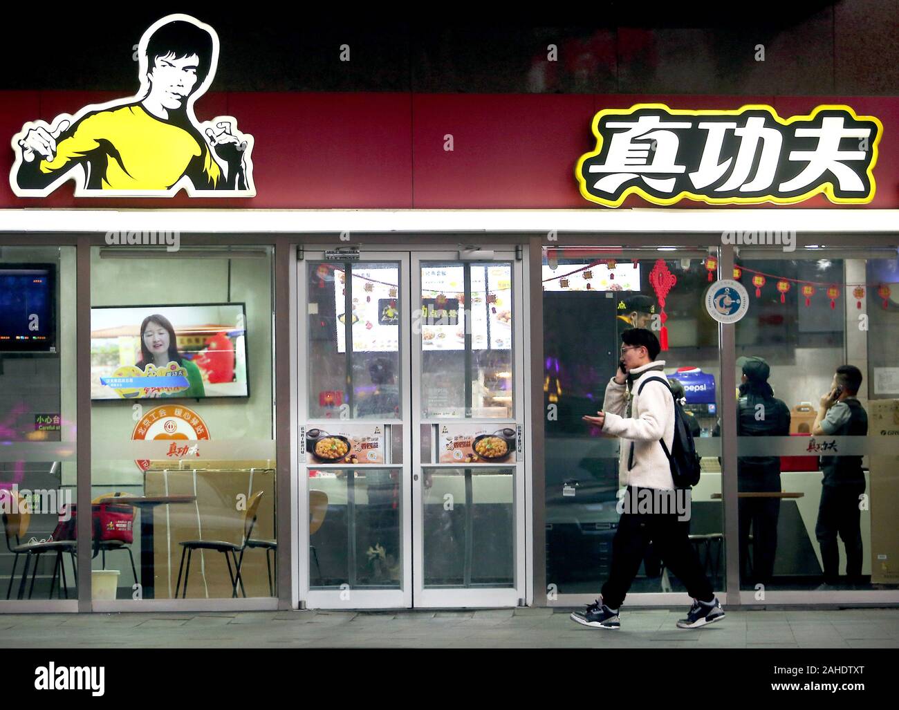 Beijing, China. 28th Dec, 2019. Chinese order food at a fast food restaurant, featuring the iconic fighting stance of Bruce Lee, in Beijing on Saturday, December 28, 2019. A company owned by Bruce Lee's daughter is suing a Chinese fast food chain for allegedly using the late martial arts star's image without permission. Intellectual rights protection is an ongoing problem in China. Photo by Stephen Shaver/UPI Credit: UPI/Alamy Live News Stock Photo