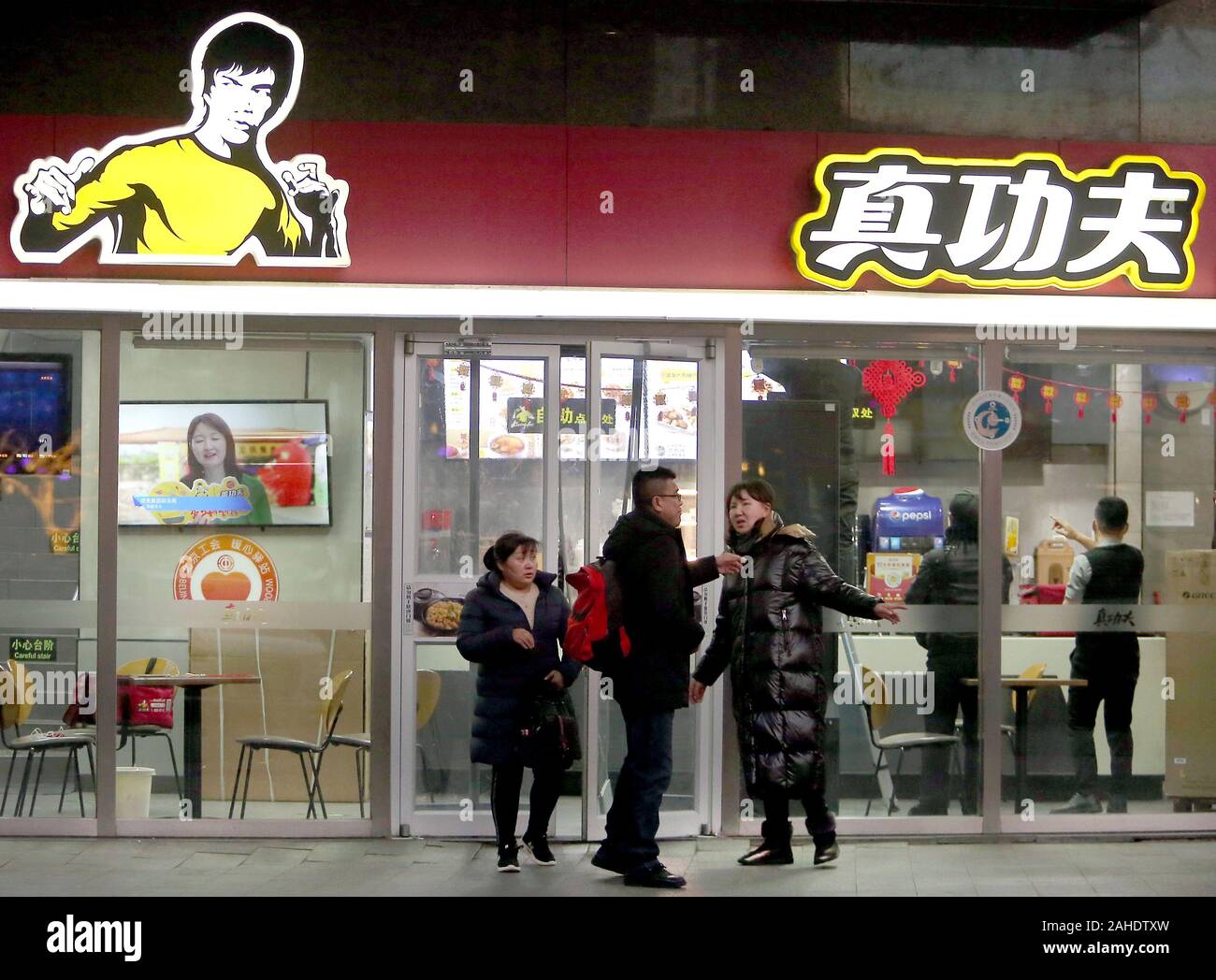 Beijing, China. 28th Dec, 2019. Chinese order food at a fast food restaurant, featuring the iconic fighting stance of Bruce Lee, in Beijing on Saturday, December 28, 2019. A company owned by Bruce Lee's daughter is suing a Chinese fast food chain for allegedly using the late martial arts star's image without permission. Intellectual rights protection is an ongoing problem in China. Photo by Stephen Shaver/UPI Credit: UPI/Alamy Live News Stock Photo