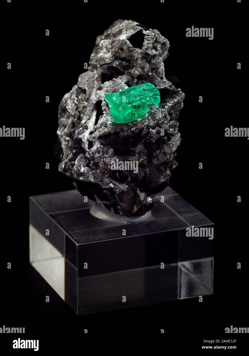 rock with raw emerald crystal with black background Stock Photo