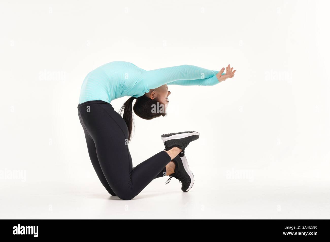Young athletic woman making yoga and gymnastics stretching exercises ...