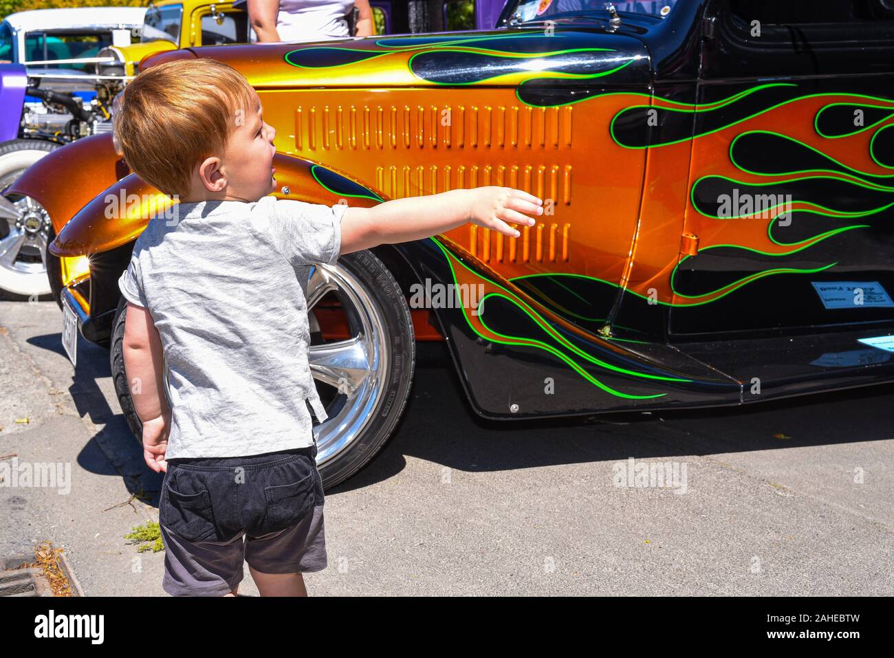Methven, New Zealand. 28th December 2019, taking a shine to a brightly painted custom car as a sunny day brings out the crowds for a gathering of hot rods and other custom cars on the southern island of New Zealand. Stock Photo