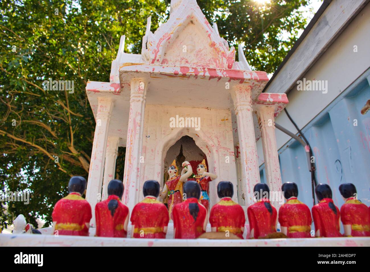 This photo shows a look into a small Buddhist temple in Thailand where beautiful ceramic figures are dancing Stock Photo