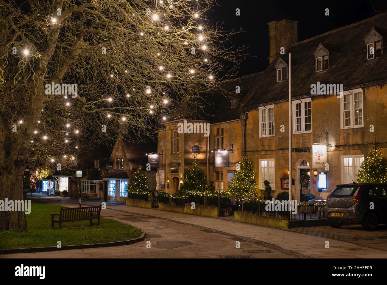 Christmas trees and decorations along the high street in Broadway at night. Broadway, Cotswolds, Worcestershire, England Stock Photo