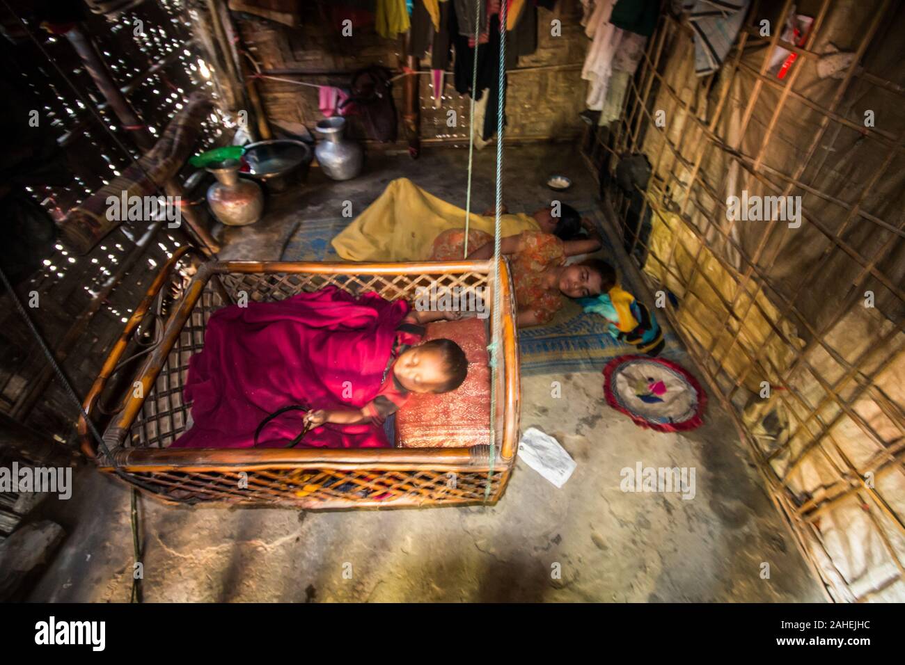 A baby aside with its mother sleeping at the Leda Refugee Camp in Teknaf.Leda makeshift settlement is a refugee camp constructed for Rohingya refugees on government-owned land in Nhilla Union of the Teknaf sub-district in Cox's Bazar, Bangladesh. The camp is located some 15 km (9.3 mi) from Teknaf town. Stock Photo