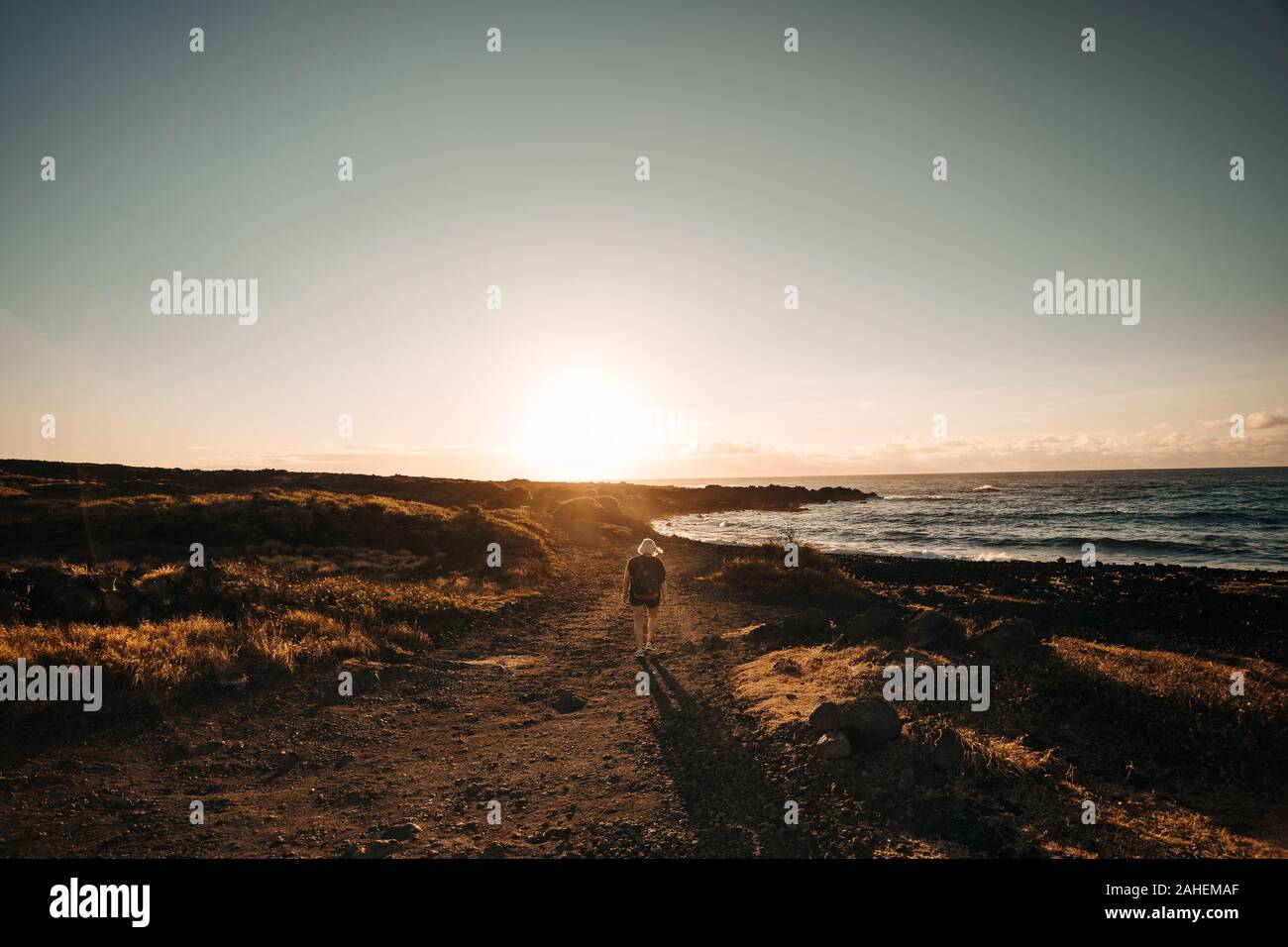 Women hikes during sunrise next to the Sea Stock Photo