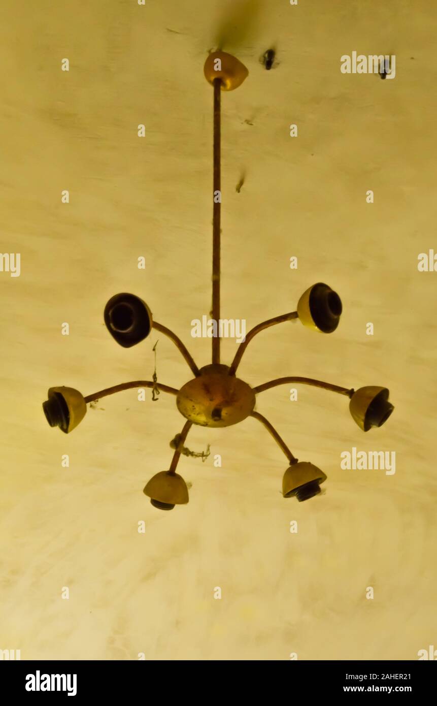 An old broken chandelier on a yellow ceiling Stock Photo Alamy