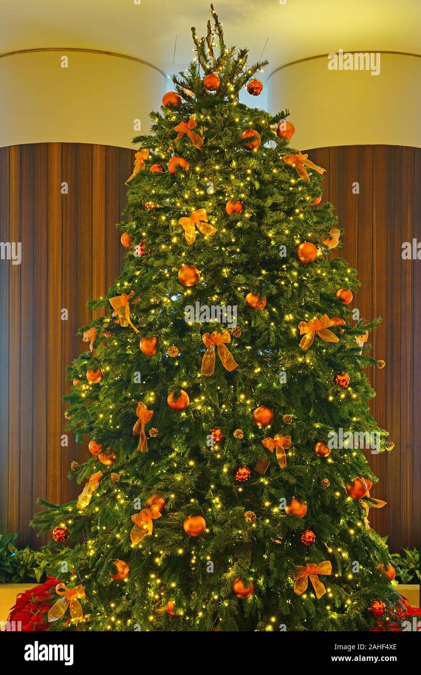 A large Christmas tree decorated with holidays ornaments and fabric