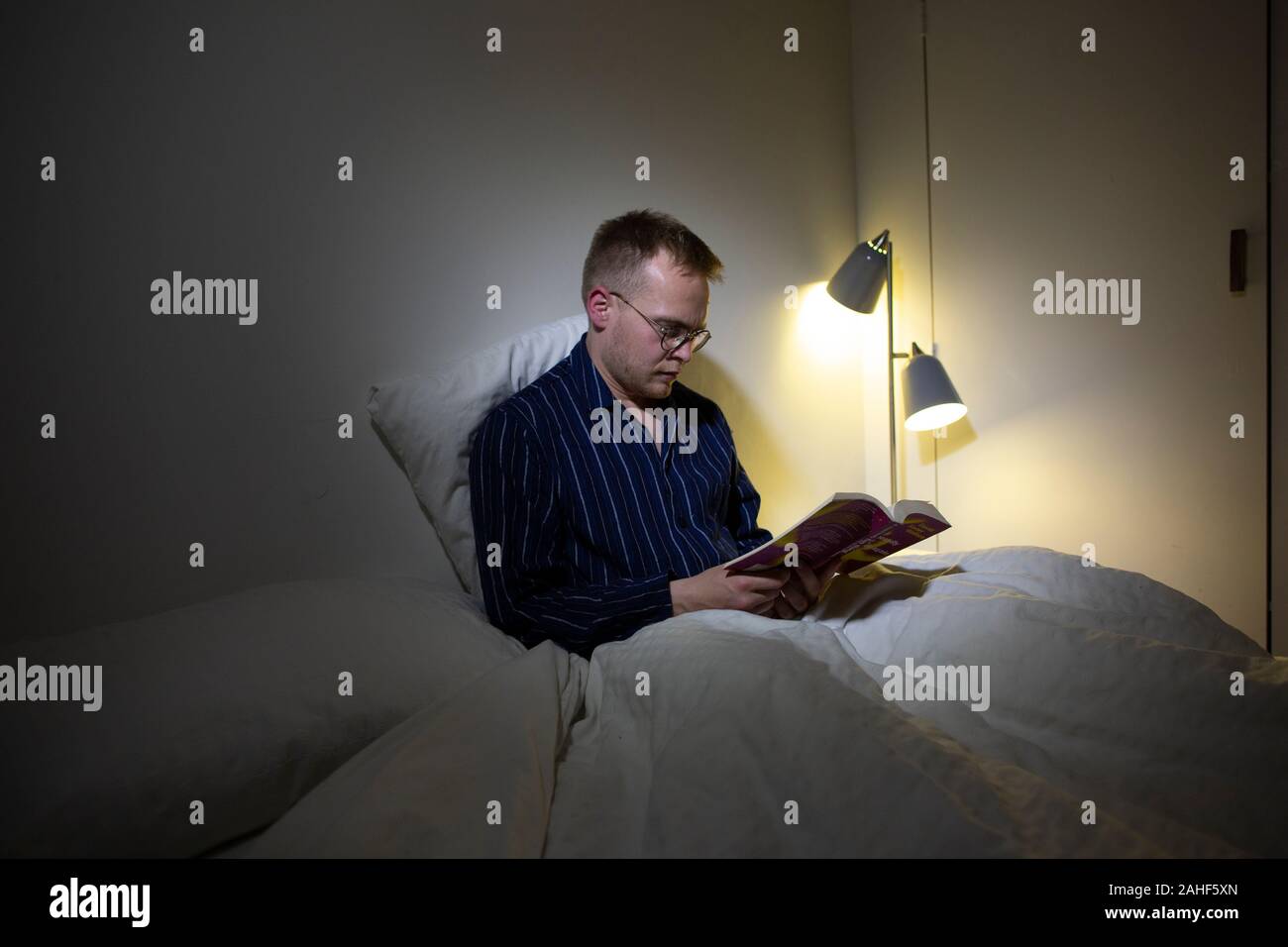 Man in his thirties engaging in 'segmented sleep'. Waking up for an hour in the night has been argued to be humans natural state. Stock Photo