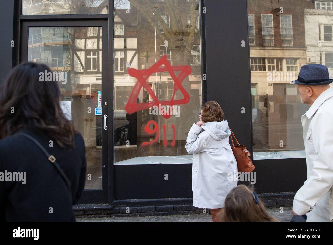 Anti-semitic graffiti in the form of numbers, 9 11, and a Star of David, on a shop window in Belsize Park, North London. Stock Photo