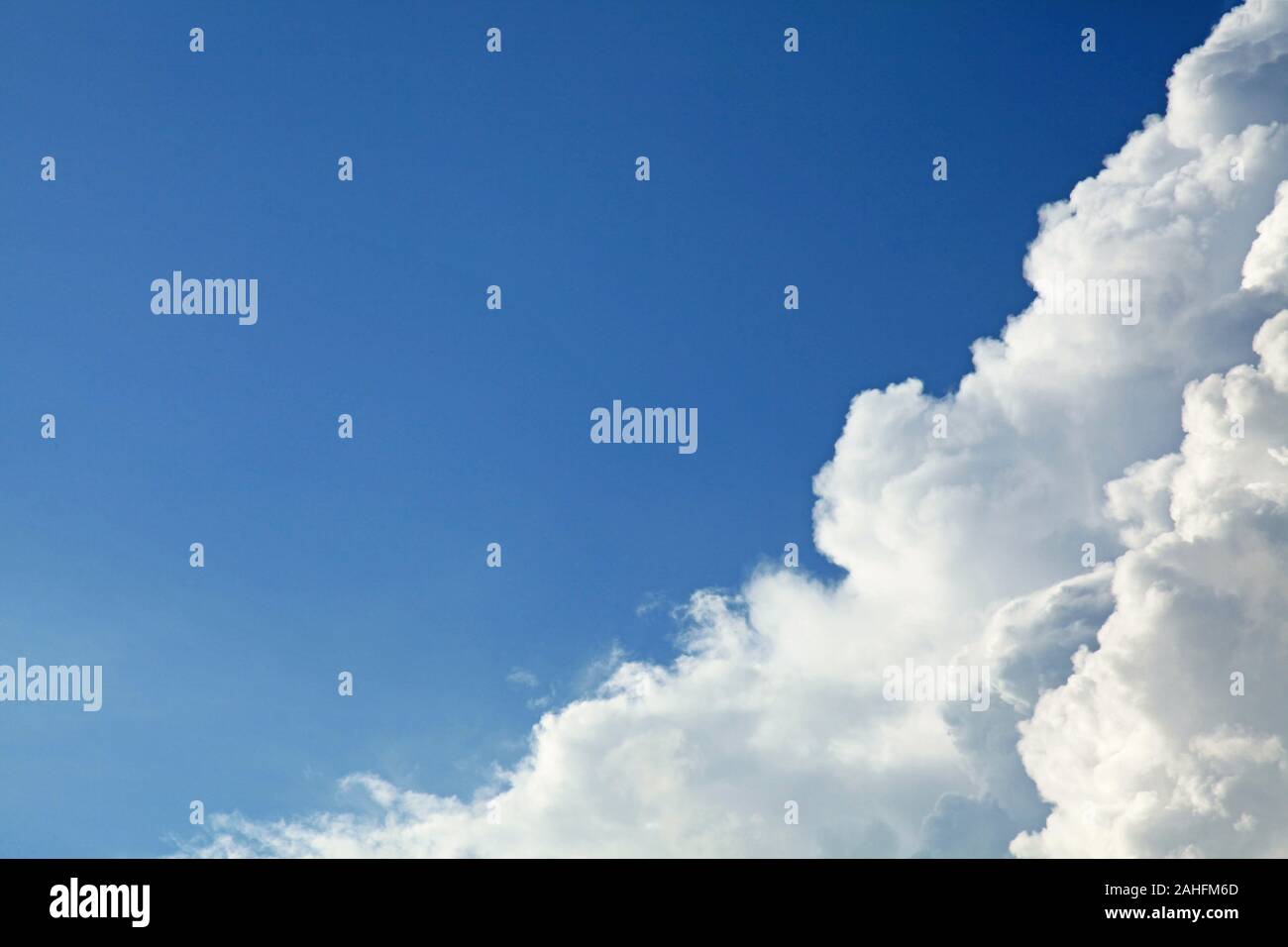A huge cumulus and cumulonimbus clouds conglomeration on the blue sky background. The skies landscape in summer Stock Photo