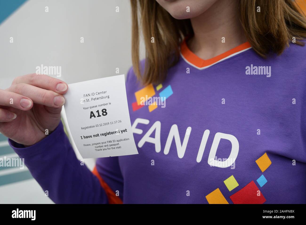 St. Petersburg, Russia - December 3, 2019: Employee holds the ticket of  electronic queue during the opening of the Fan ID Center for UEFA Euro  2020. Three group matches and quarterfinal will