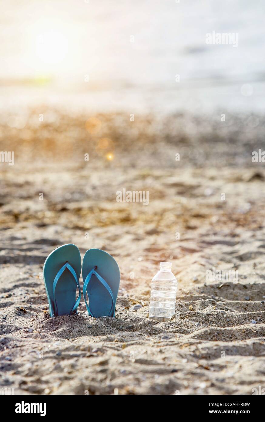 Flip flops on beach sand with bottled water Stock Photo - Alamy