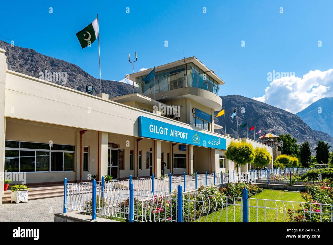 Gilgit Domestic Airport Air Traffic Control Tower with Waving Pakistan Flag on a Sunny Blue Sky Day Stock Photo