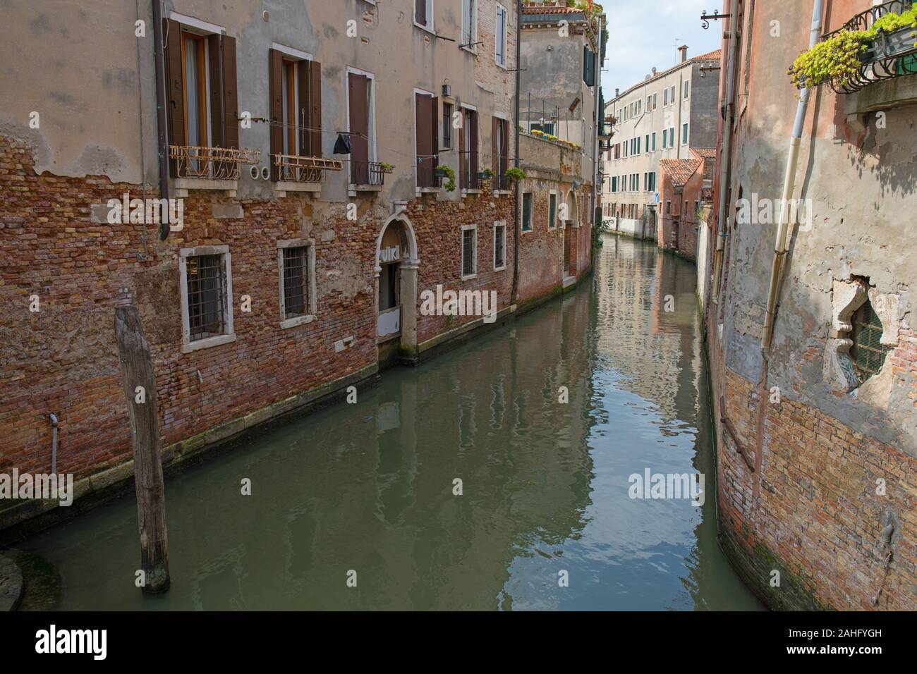 Photo of one of the many canals in the old town of Venice, Italy. The town with the historic buildings are visited by 30 million tourists every year. Stock Photo