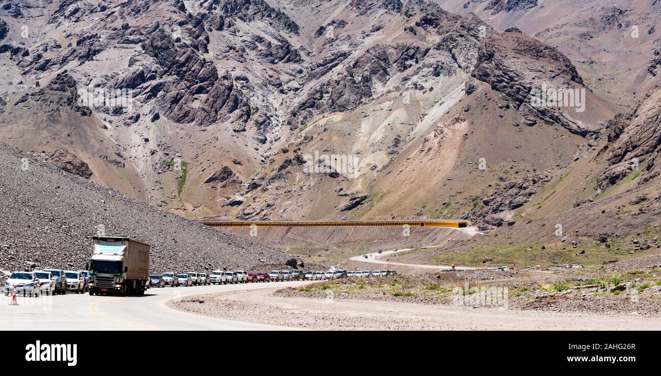 A queue of traffic waiting to leave Argentina and enter Chile at the border crossing in the Andes. Stock Photo