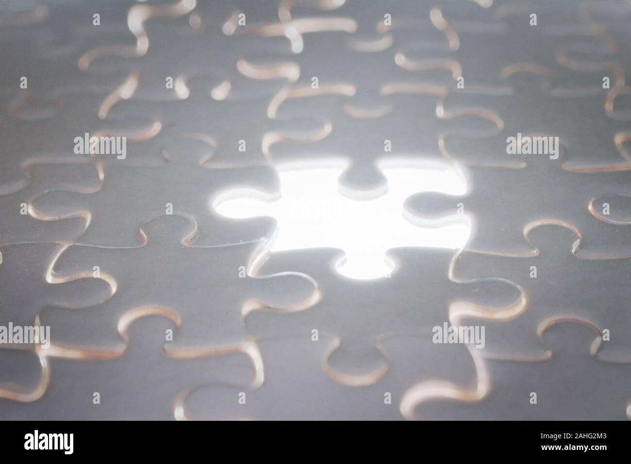 White blank jigsaw puzzle with blank illuminated piece. Selective focus Stock Photo