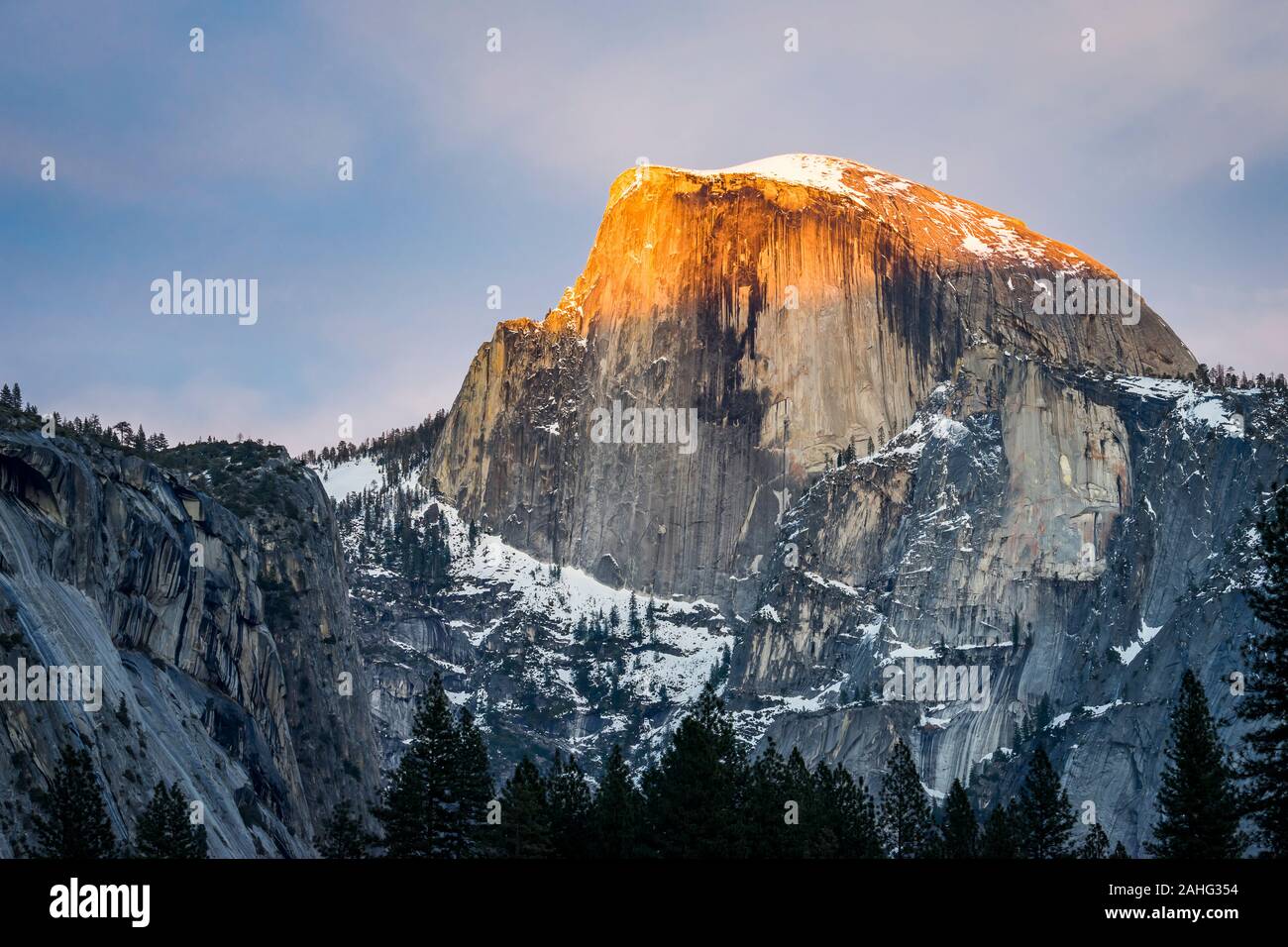 Landscape image of snow-capped Half Dome, Yosemite National Park, with alpenglow Stock Photo