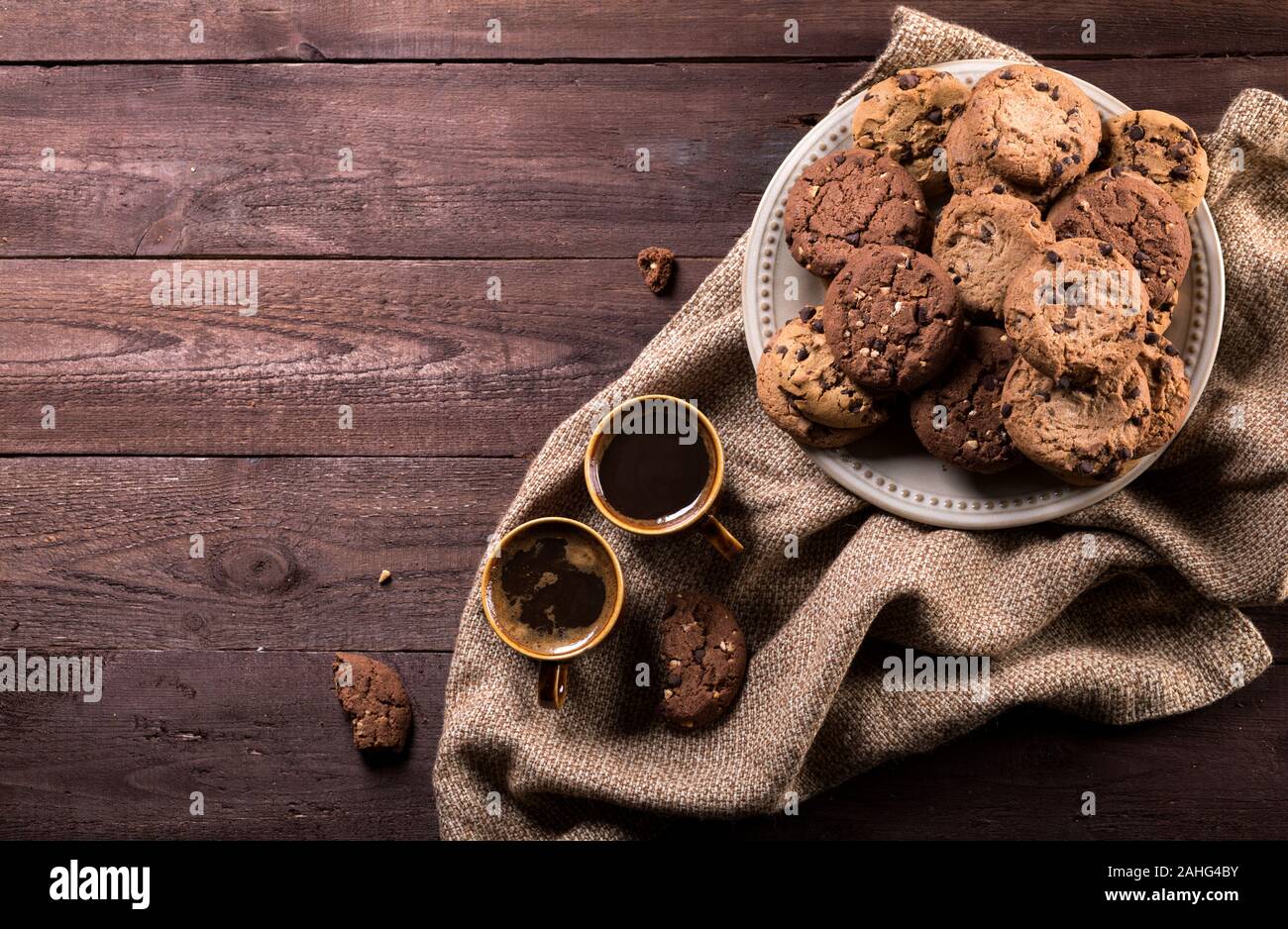 Two cups of coffee and chocolate chip cookies on rustic wooden