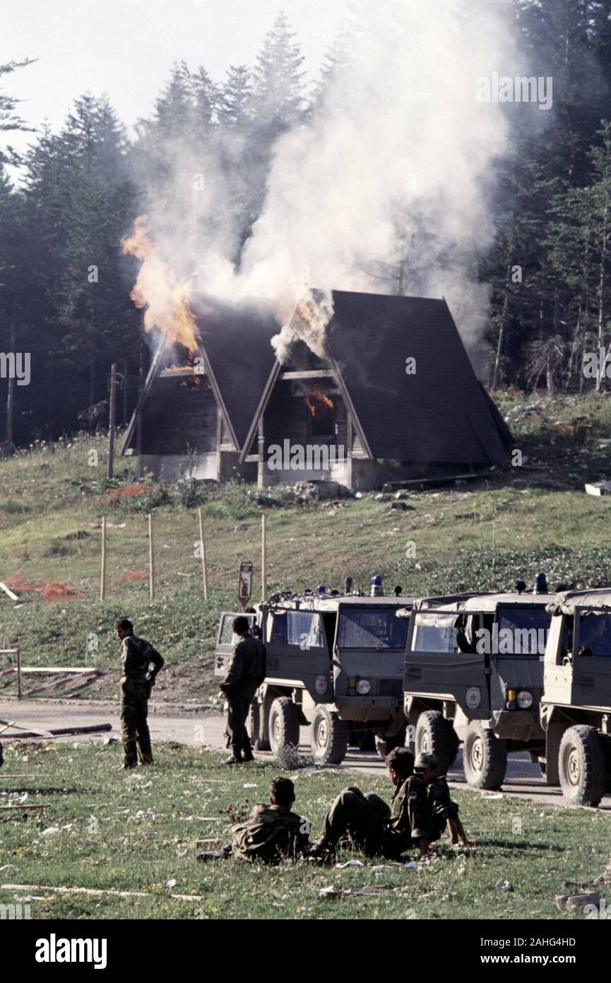 13th August 1993 During the war in Bosnia: wooden chalets of the Hotel Famos (today called the Hotel Maršal) burn behind victorious BSA (Bosnian-Serb) soldiers on Bjelašnica mountain. Stock Photo