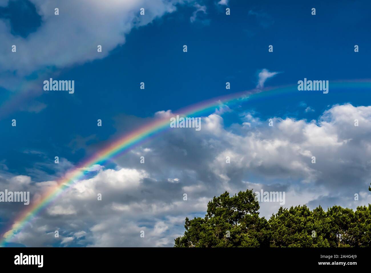 Rainbow against a blue sky with clouds Stock Photo
