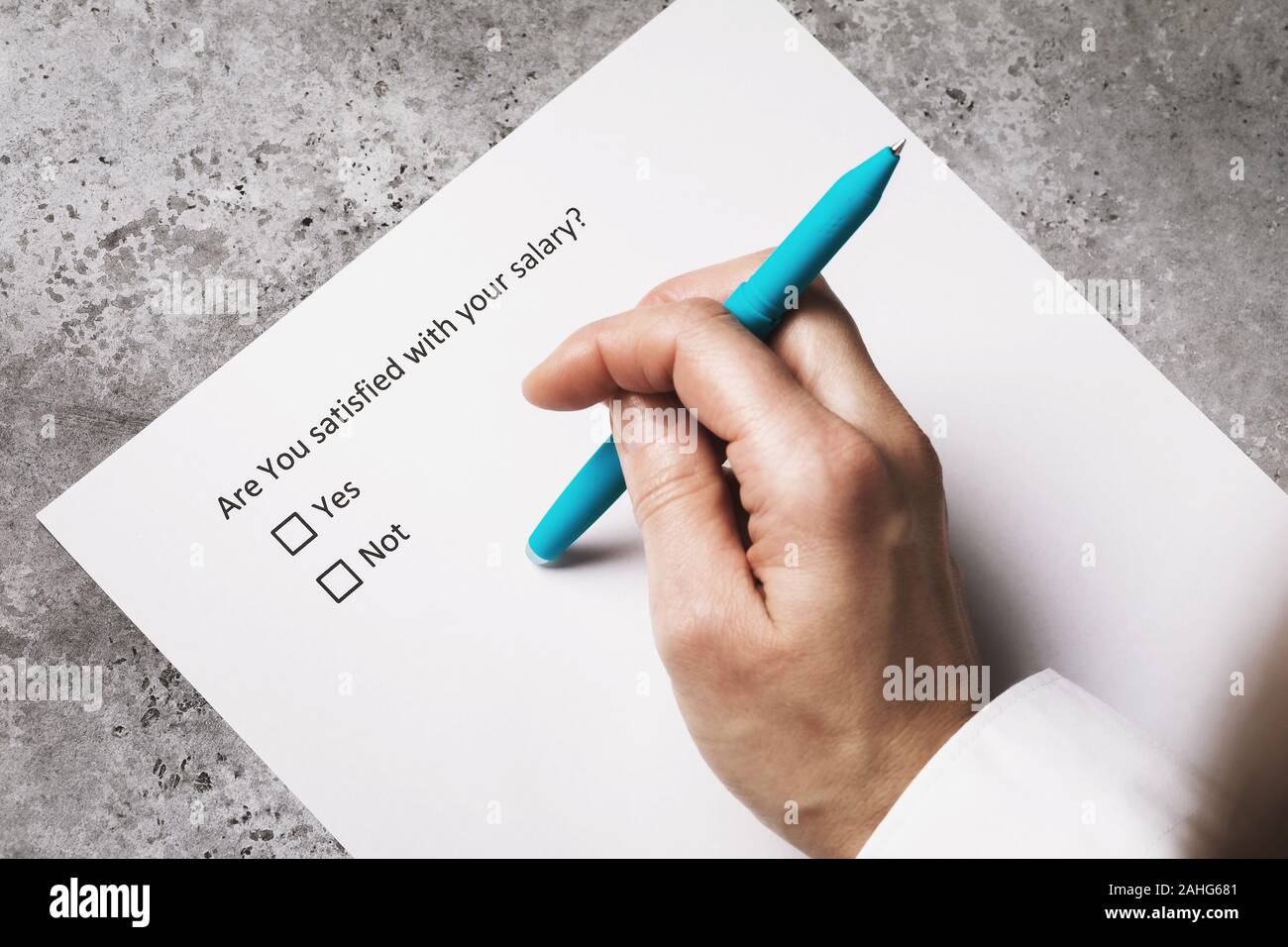 Hand with pen on a sheet of paper. Concept on anonymous salary survey Stock Photo