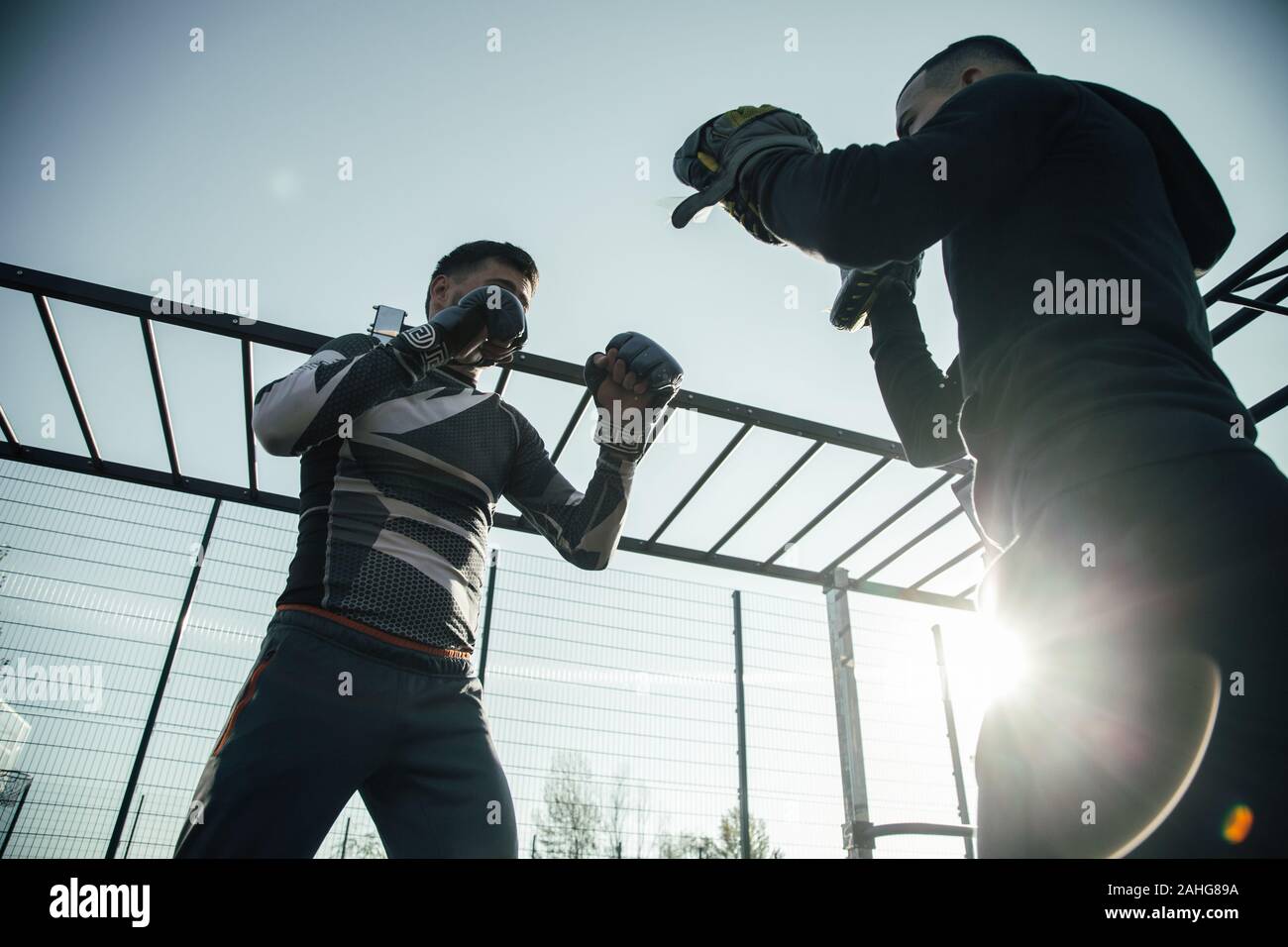 Laconic image of two men performing boxing stances outdoors Stock Photo