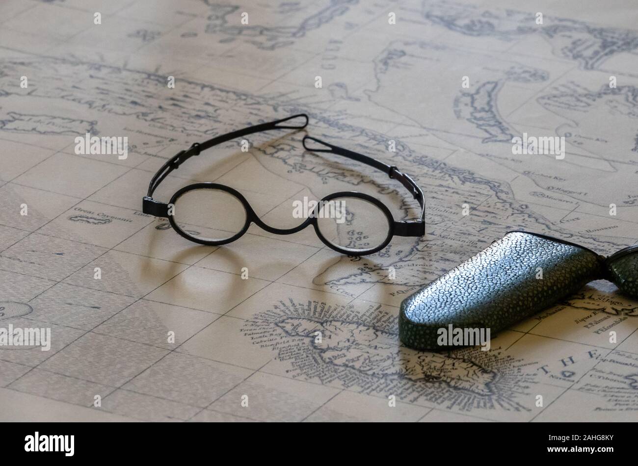 Pair of round magnifying spectacles on top of old sea faring map Stock Photo