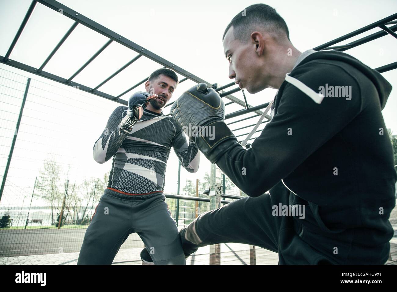 Two boxers looking serious while fighting outdoors at the training Stock Photo