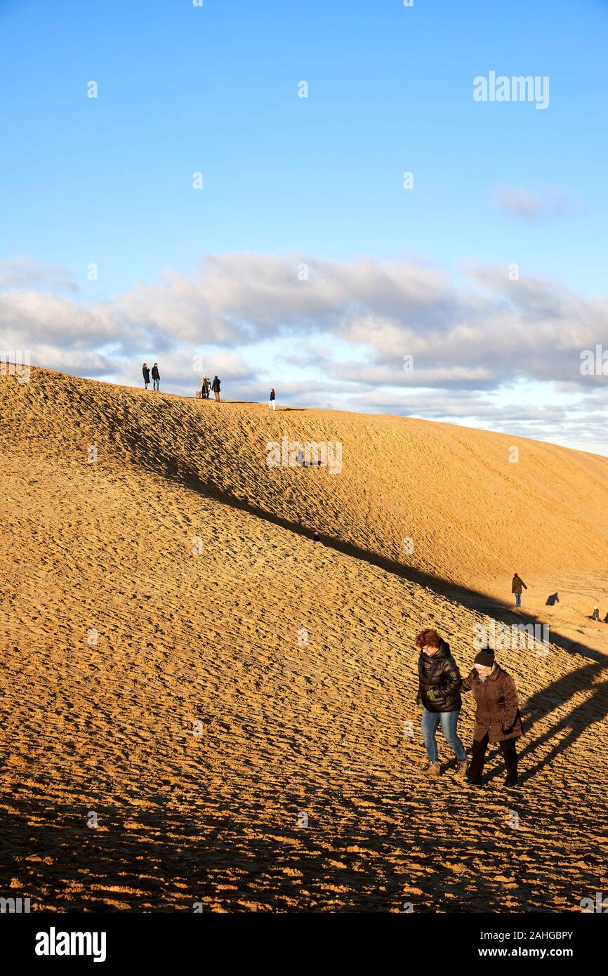 People walking in the sand dunes by Rubjerg Knude Lighthouse (Rubjerg Knude Fyr); Denmark Stock Photo