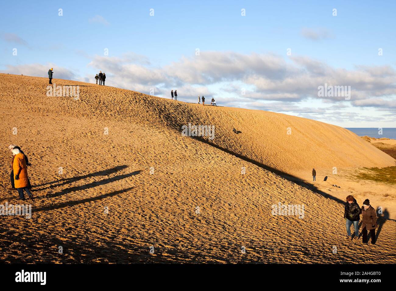People walking in the sand dunes by Rubjerg Knude Lighthouse (Rubjerg Knude Fyr); Denmark Stock Photo