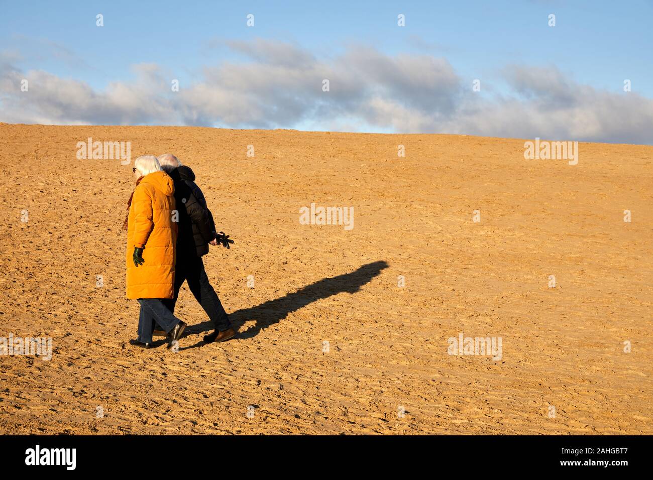 Elderly couple walking in the sand dunes by Rubjerg Knude Lighthouse (Rubjerg Knude Fyr); Denmark Stock Photo