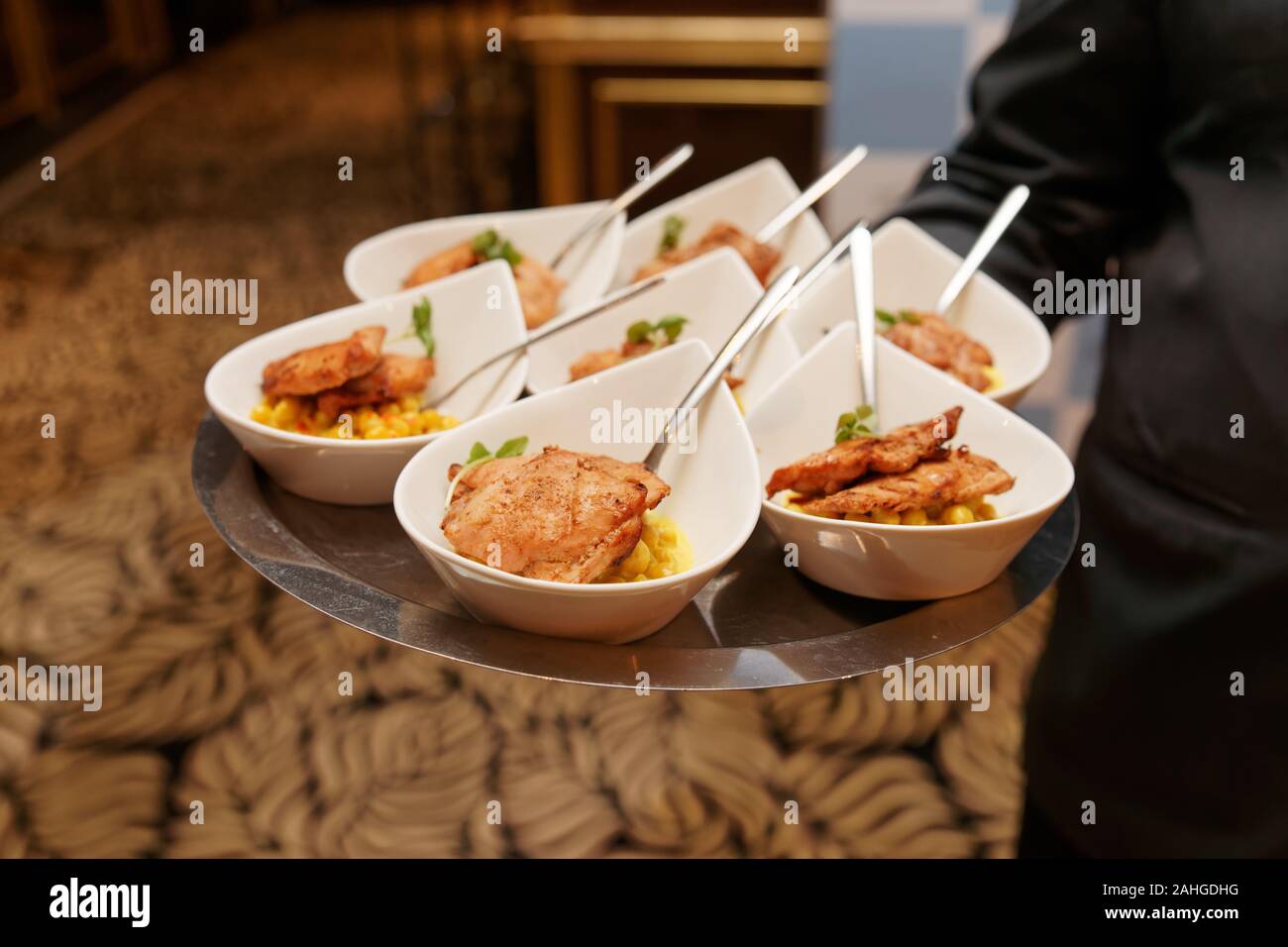 Waiter carries tray with banquet food plates Stock Photo