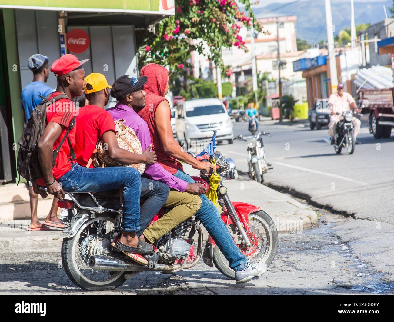dramatic image of four Haitian men on a motorbike in a small mountain