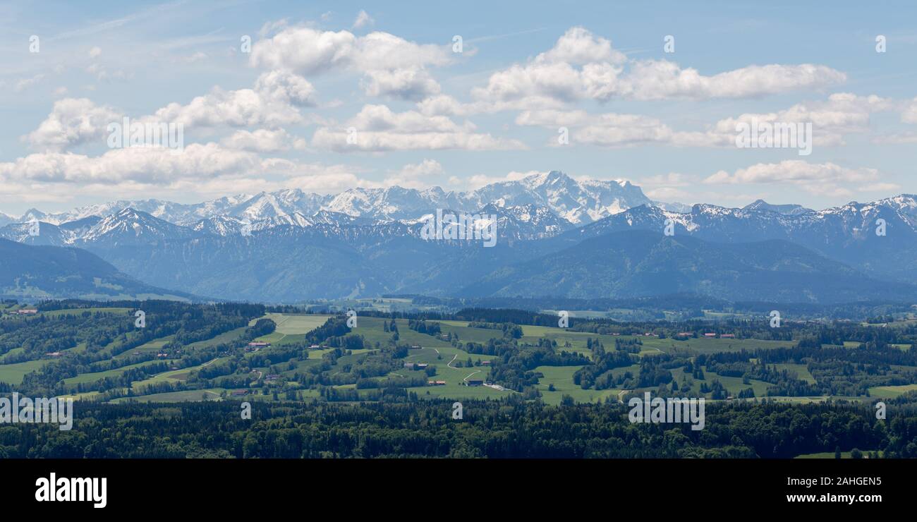 View on Wetterstein mountain range. Blue sky with white clouds. Zugspitze, Germanys highest mountain enthroned in the middle. Stock Photo