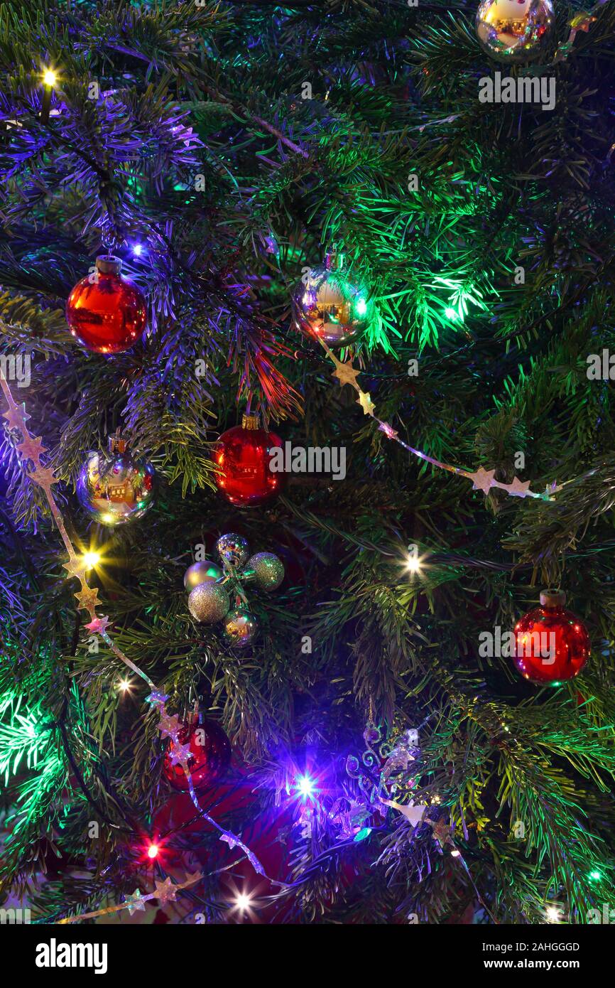 Decorations on Christmas tree, baubles, tinsel and lights in close-up, Surrey, UK Stock Photo