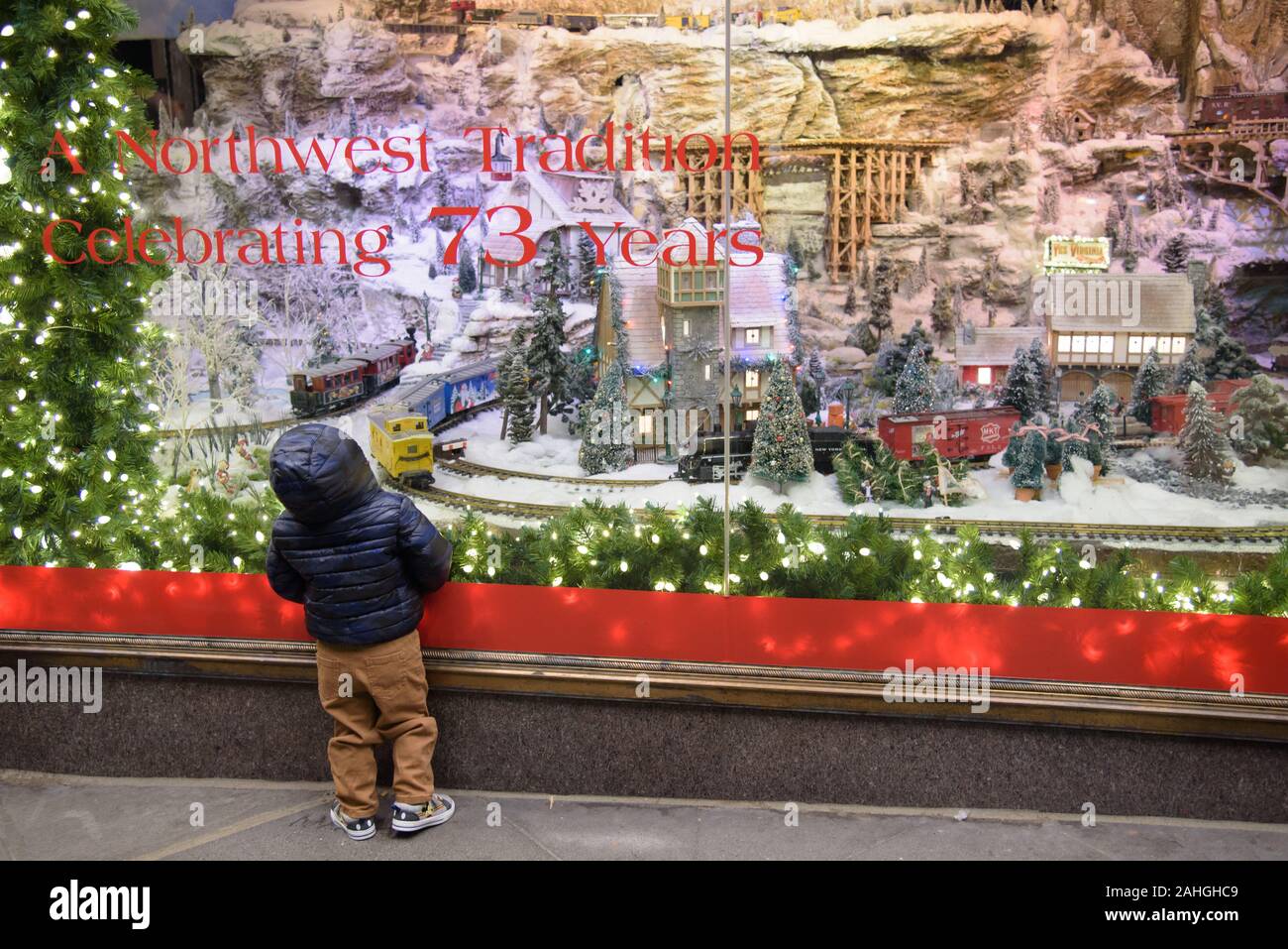 Child gazes in wonder at Macy's final store window display decorated for Christmas in downtown Seattle. Macy's is closing, ending a 73-year tradition. Stock Photo
