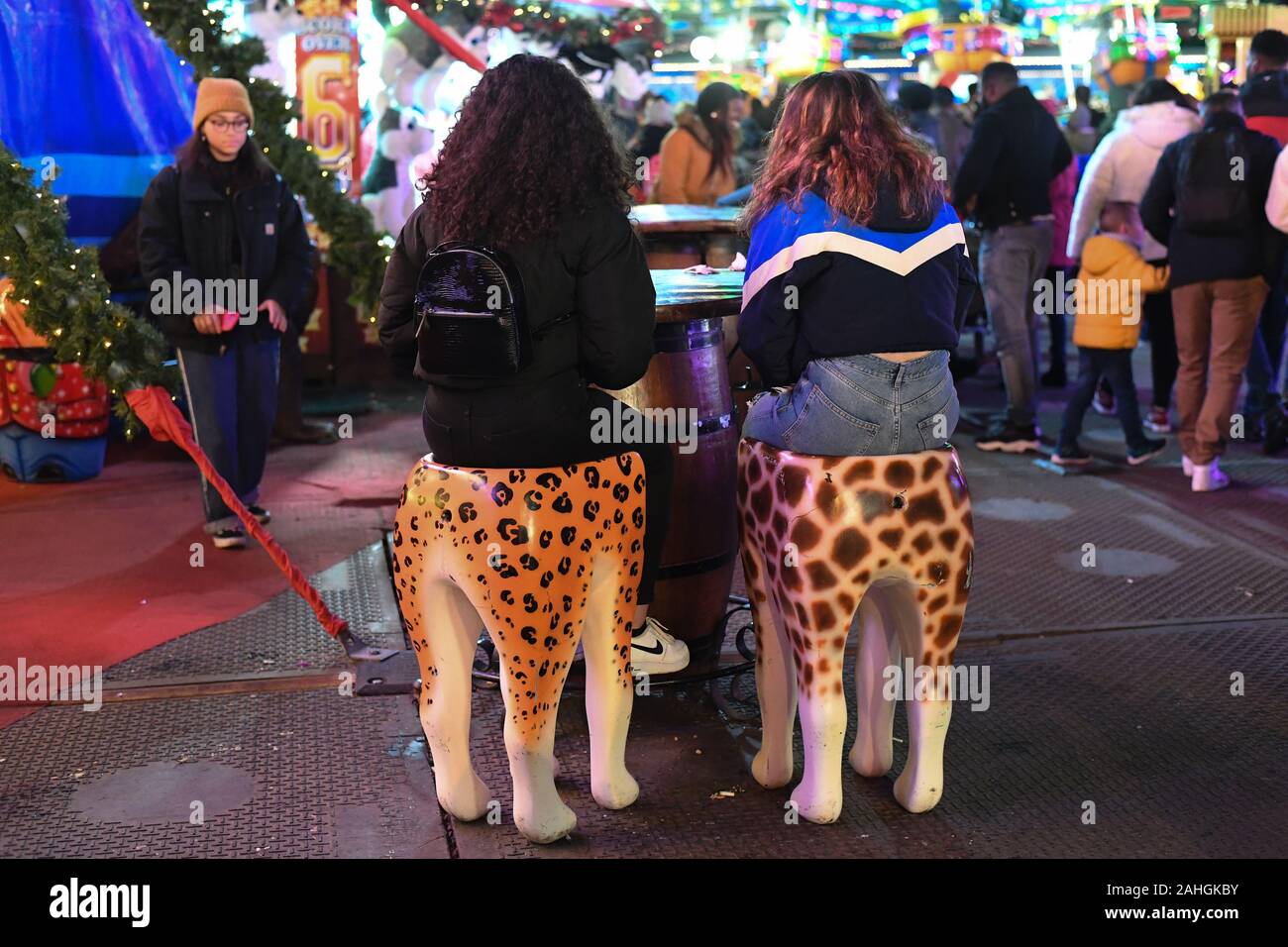 Visitors sit on animal stools at Winter Wonderland in Hyde Park, London. PA Photo. Picture date: Sunday December 29, 2019. Photo credit should read: Kirsty O'Connor/PA Wire Stock Photo
