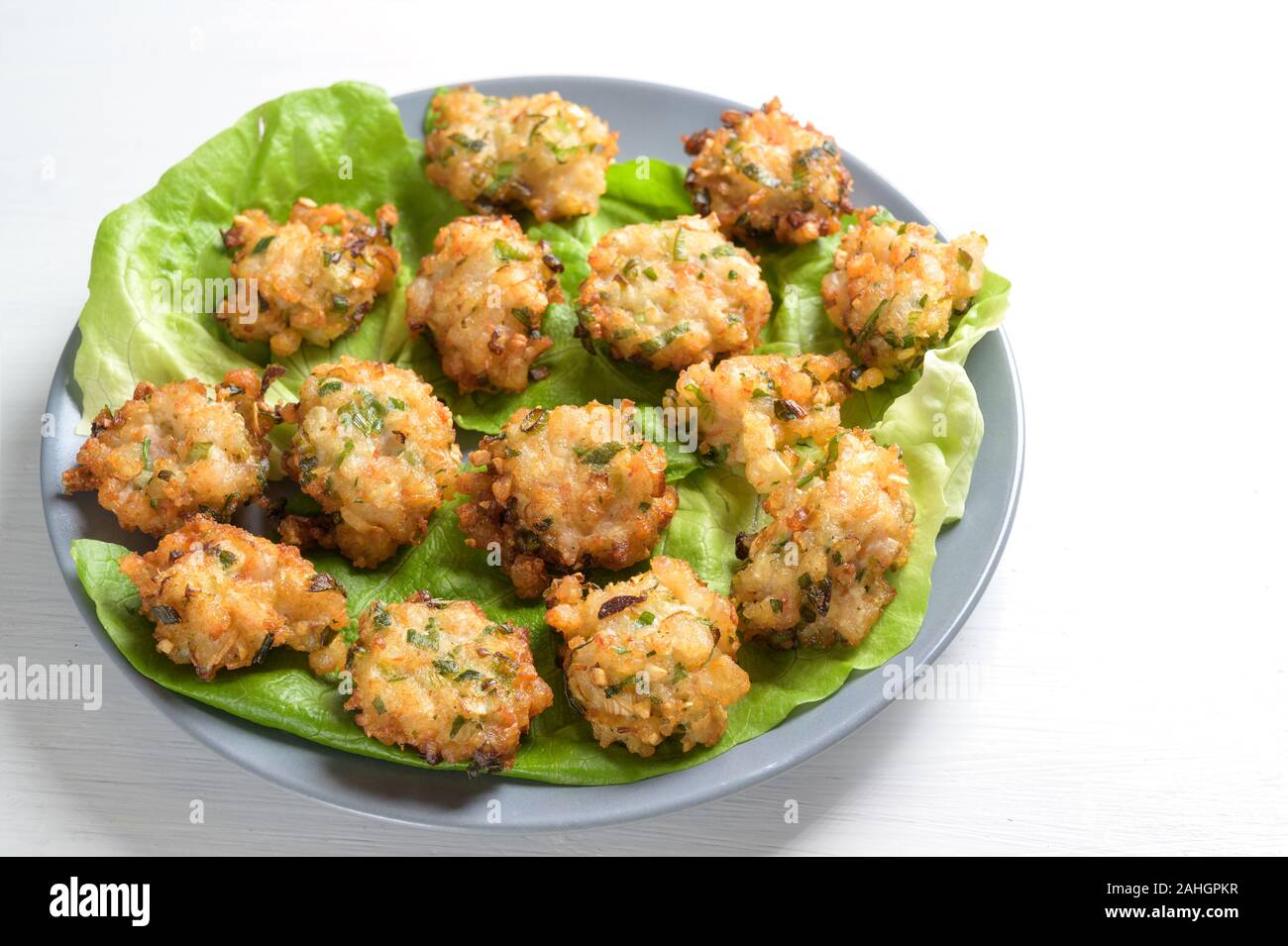 fried prawn heaps with garlic and spring onions, appetizer finger food for a festive party buffet on a white table, copy space Stock Photo
