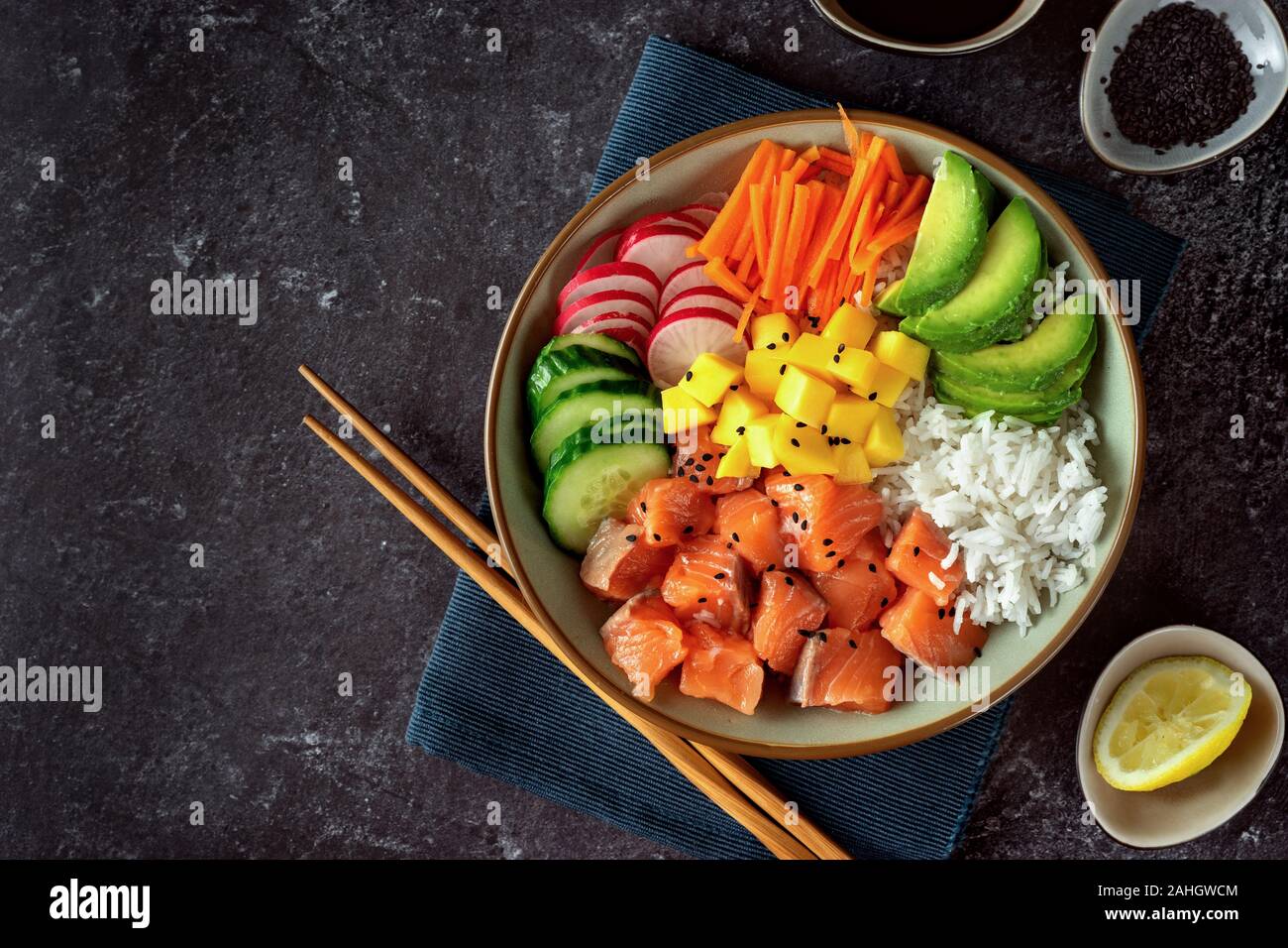 Top view of salmon poke bowl with avocado, rice, pickled carrots and ...