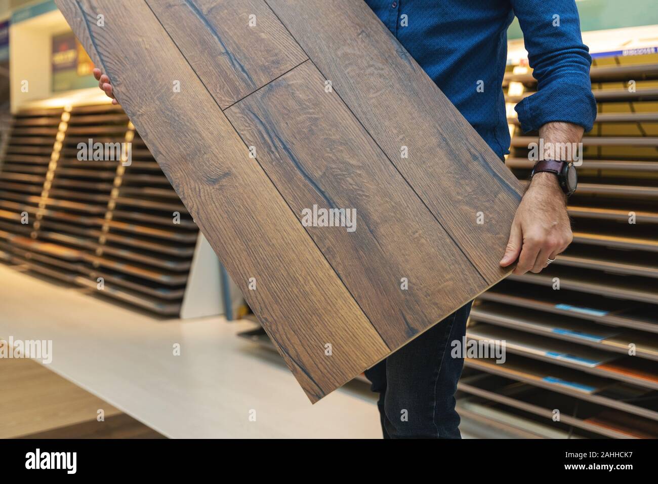 flooring store salesman with laminate floor sample panel in hands Stock