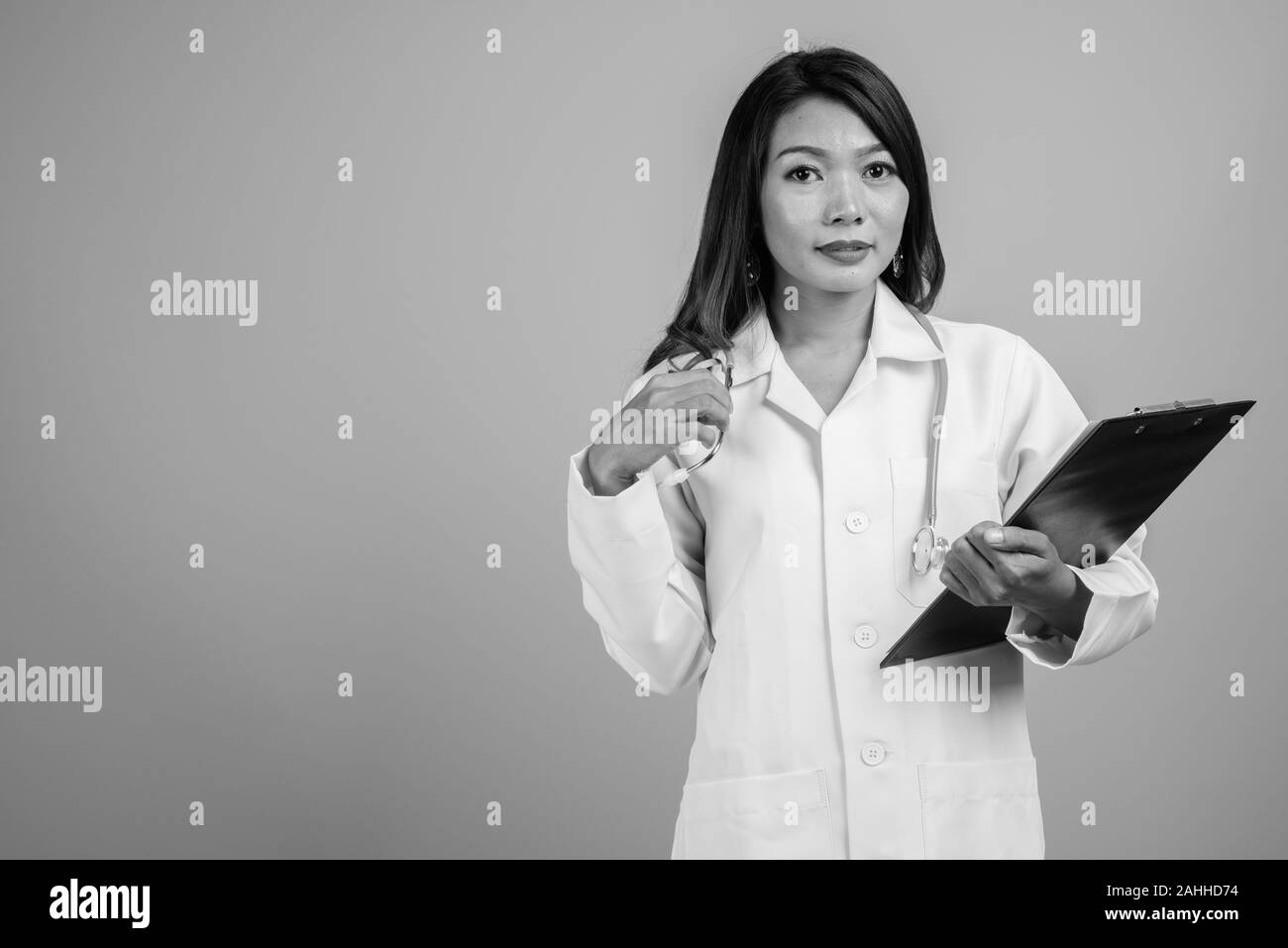 Portrait of Asian woman doctor against gray background Stock Photo - Alamy