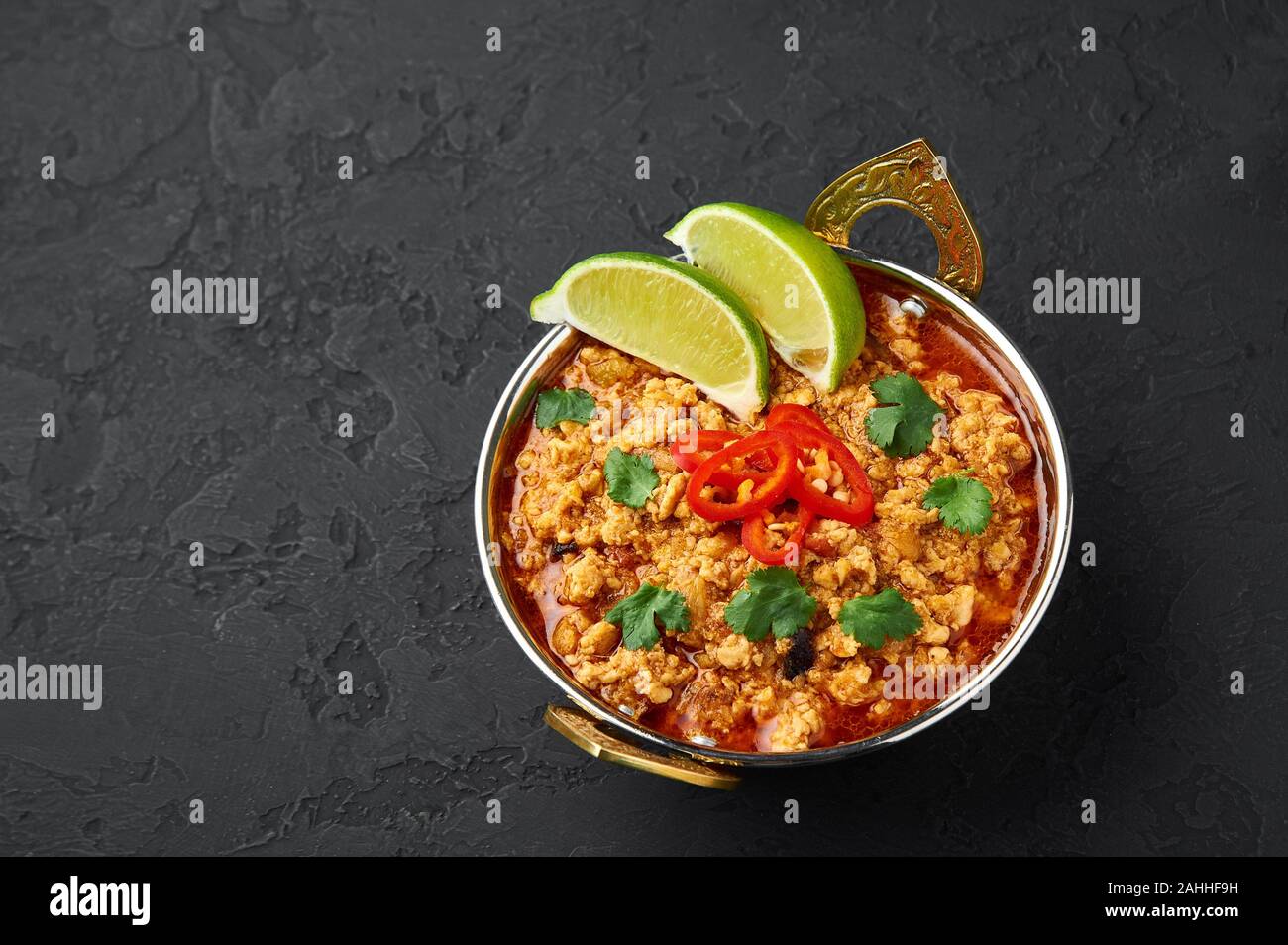 Chicken keema in traditional indian copper kadai at dark slate