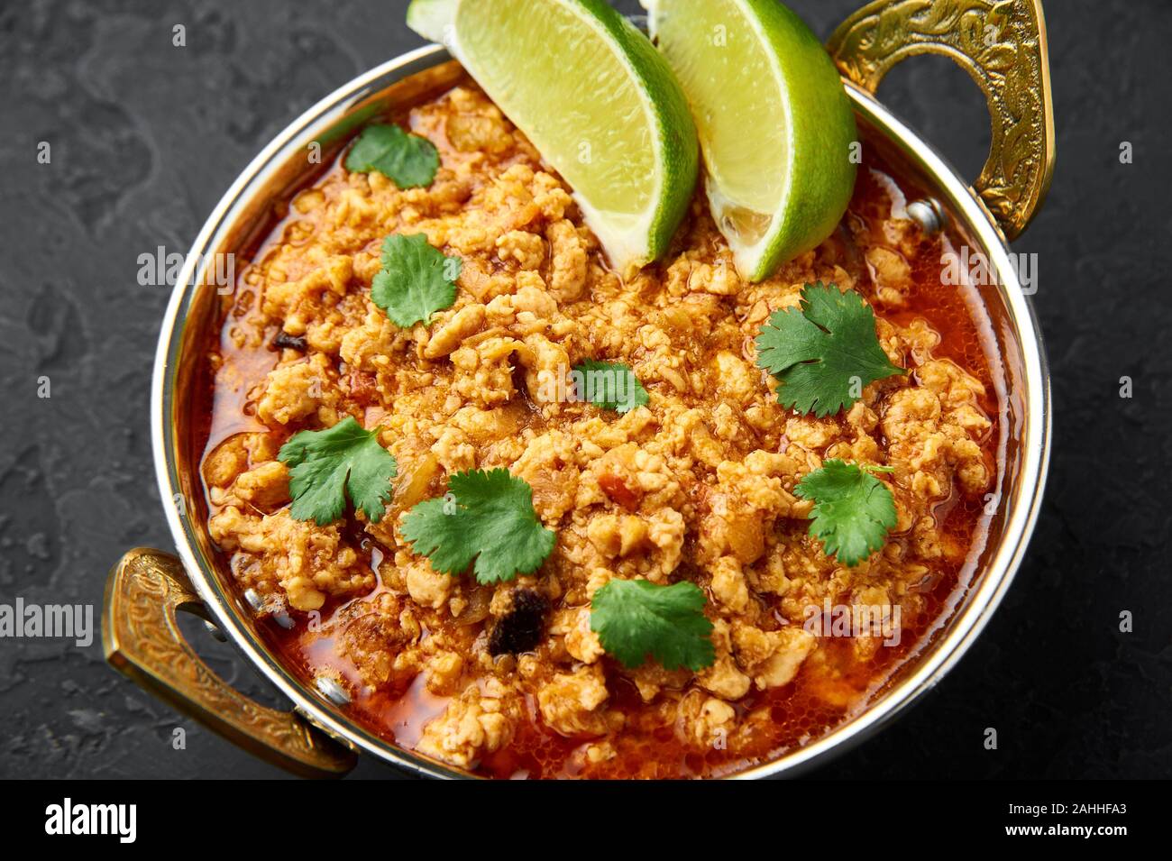 Chicken keema in traditional indian copper kadai at dark slate