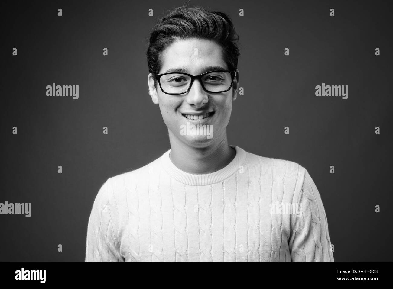 Portrait of young handsome man against gray background Stock Photo - Alamy