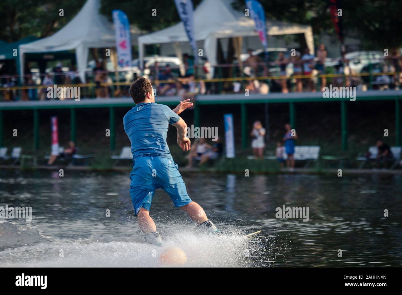 Phuket, Thailand - 22 April 2018 : man in blue slide on water with wake board and no handle line at Phuket wake park Stock Photo