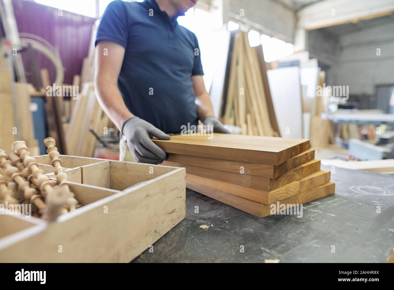 Carpentry workshop making wooden furniture. Wooden details in hands of male carpenter, woodworking industry, individual orders, designer furniture Stock Photo