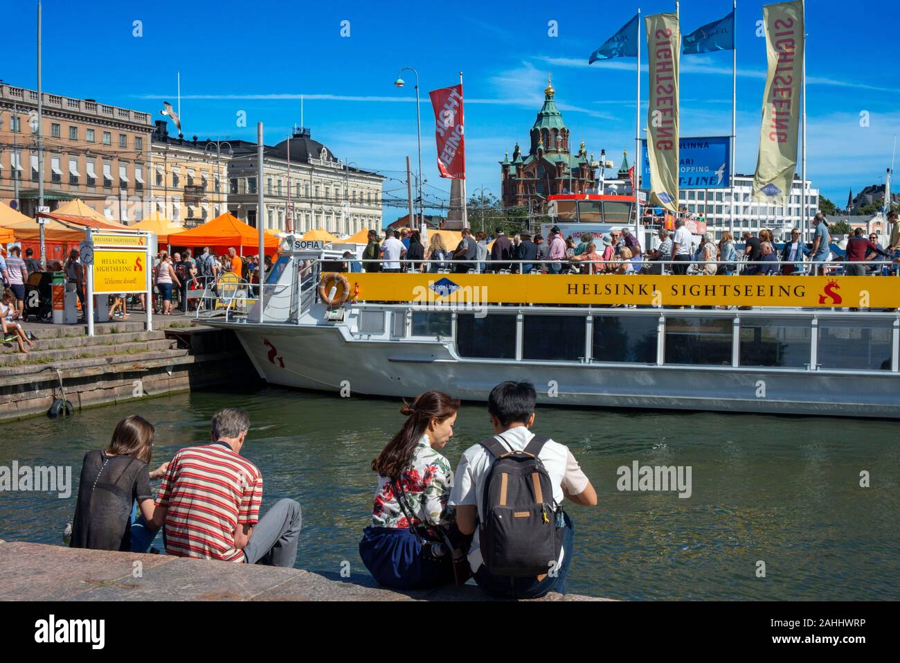 The Helsinki waterfront, with crowds of tourists and a sightseeing boat Helsinki Finland Stock Photo