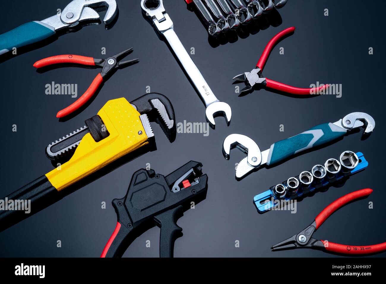 Mechanic tools on black background. Set of pipe wrench, bent wrench, nuts, spanner, pliers, and