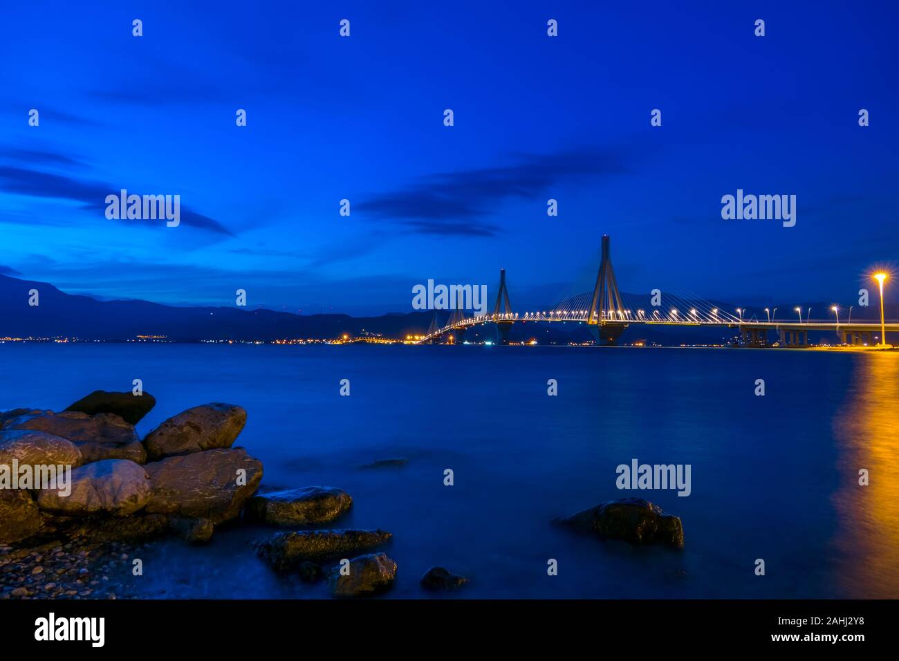 Greek cable-stayed bridge over the Gulf of Corinth. Rion-Antirion. Night sky over the mountain shore Stock Photo