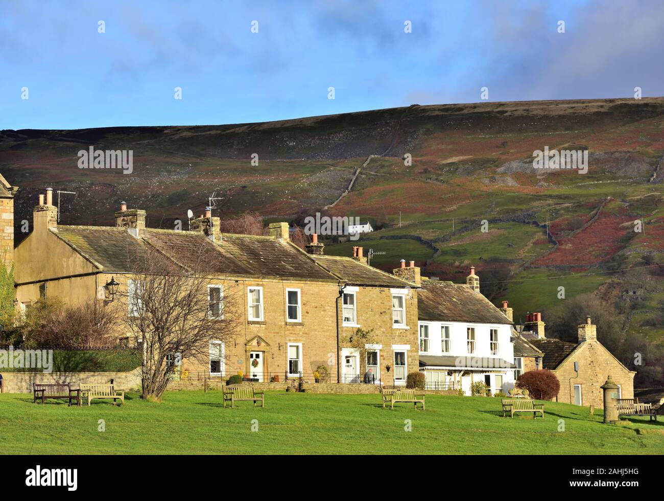 The village of Reeth, lit by winter sun and overlooked by the Fremington Edge. Stock Photo